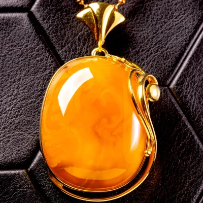 Ciondolo in ambra color miele: riflessi dorati avvolti in raffinata armonia.