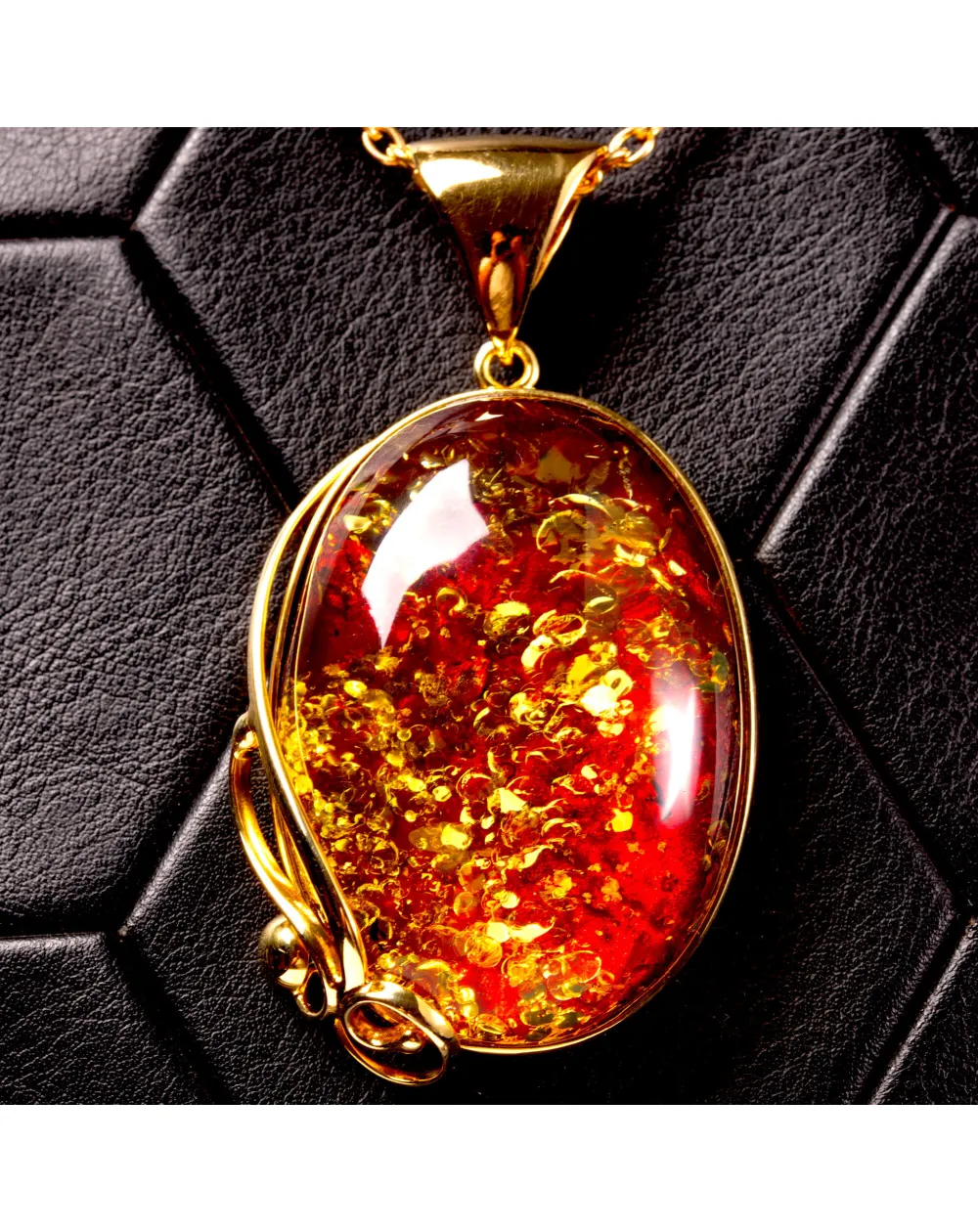 Ciondolo in ambra rosso cognac: gemma con inclusioni dorate, eleganza senza tempo.