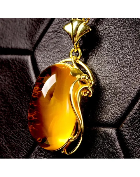 Ciondolo in ambra baltica color miele: pietra naturale incastonata in argento dorato.