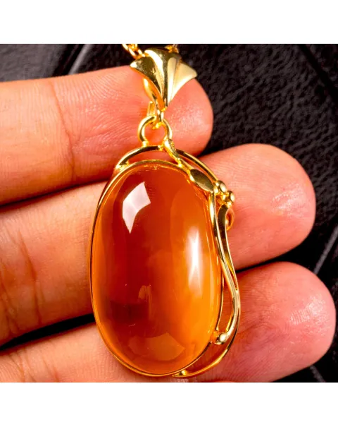 Ciondolo in ambra baltica color miele: pietra naturale incastonata in argento dorato.