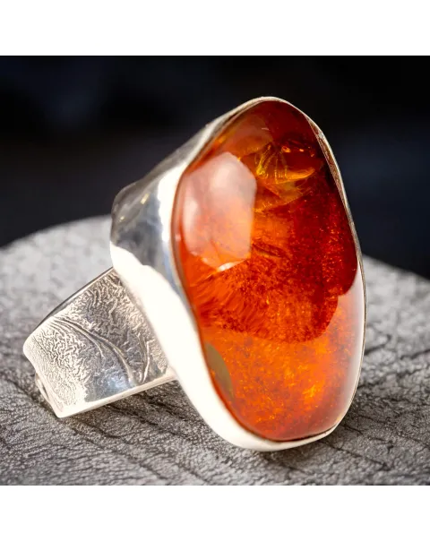 Anello in argento con ambra rossa e arancione: forza e protezione energetica.