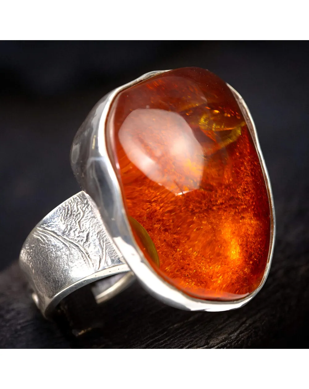 Anello in argento con ambra rossa e arancione: forza e protezione energetica.