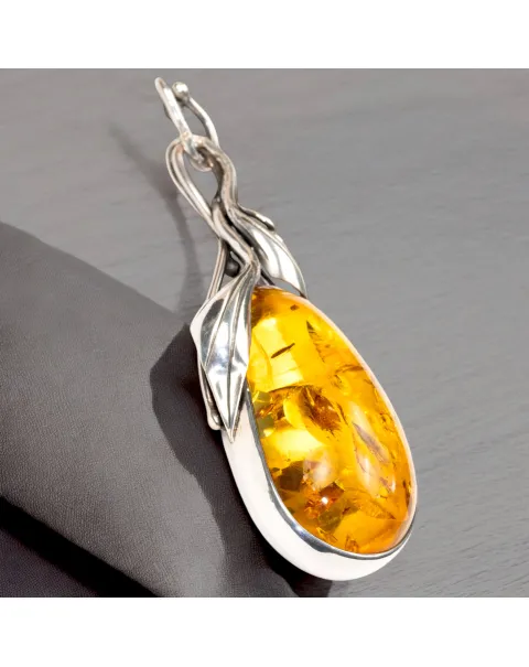 Ciondolo in argento con ambra color miele e inclusioni a forma di petali: eleganza naturale e armonia.