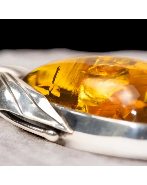 Ciondolo in argento con ambra color miele e inclusioni a forma di petali: eleganza naturale e armonia.