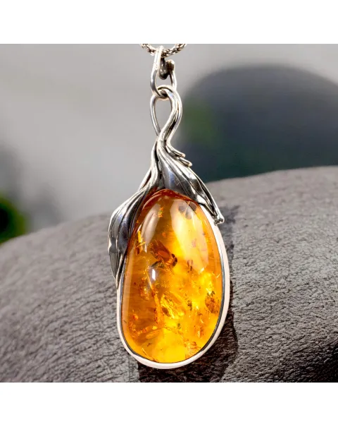 Ciondolo in argento con ambra color miele e inclusioni a forma di petali: eleganza naturale e armonia.
