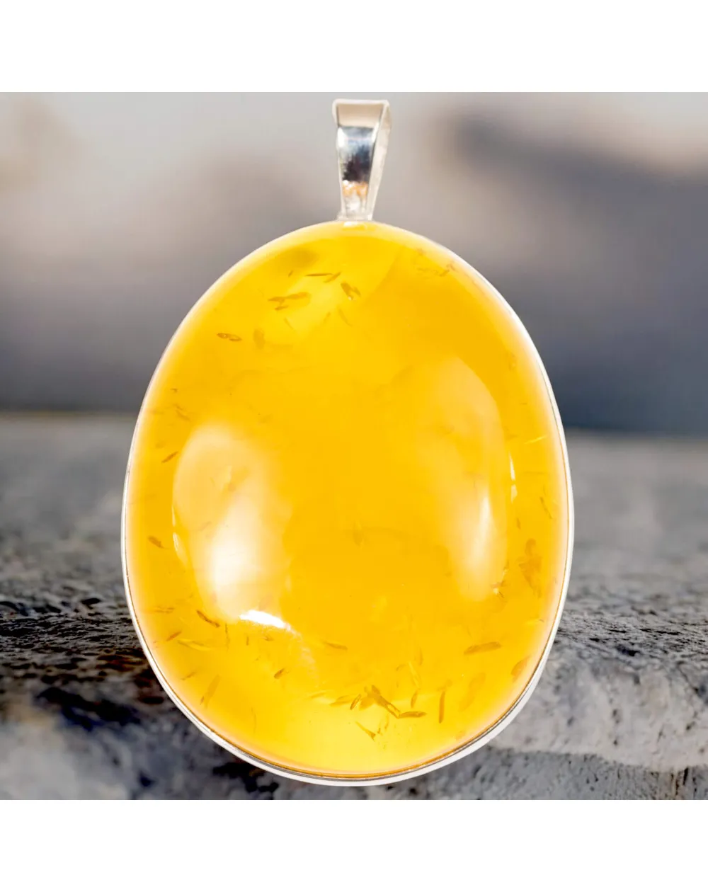 Ciondolo in argento con ambra color miele: eleganza e protezione energetica.
