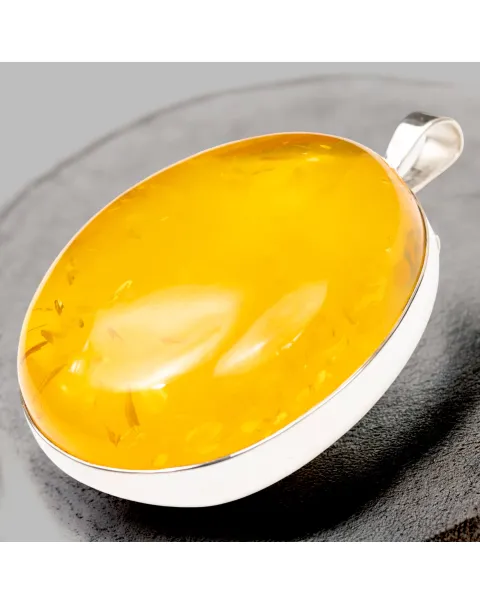 Ciondolo in argento con ambra color miele: eleganza e protezione energetica.