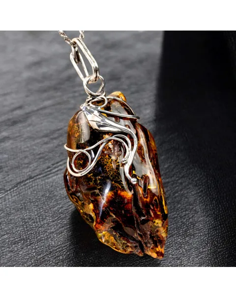 Ciondolo in argento con ambra grezza color cognac: connessione con la natura e protezione spirituale.