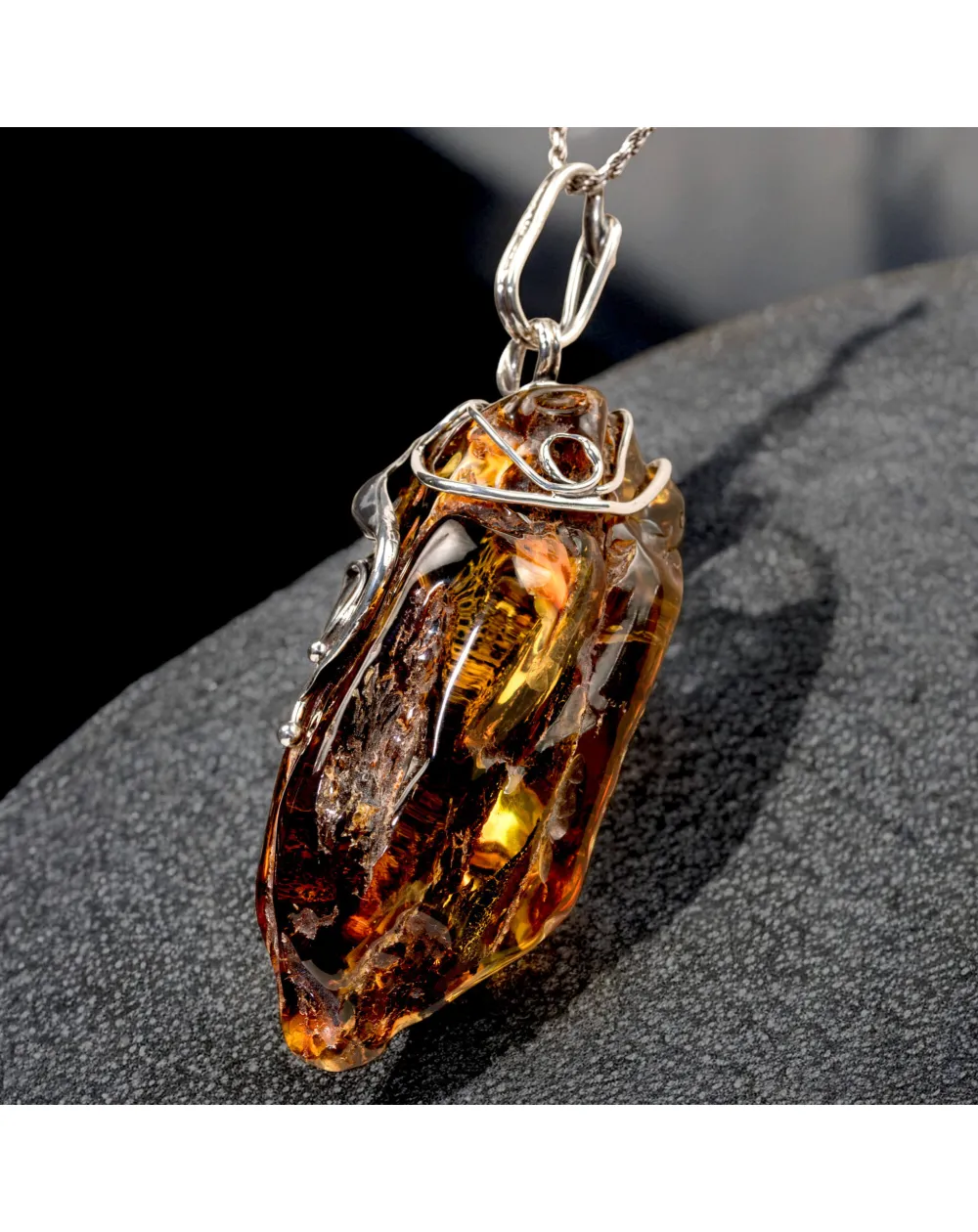 Ciondolo in argento con ambra grezza color cognac: connessione con la natura e protezione spirituale.