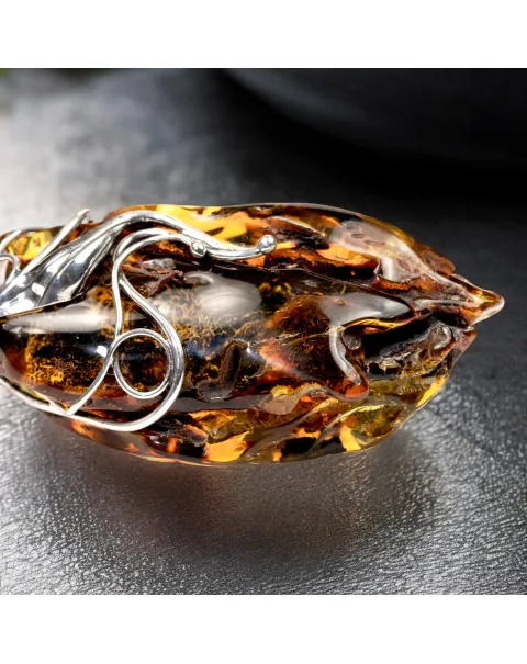 Ciondolo in argento con ambra grezza color cognac: connessione con la natura e protezione spirituale.