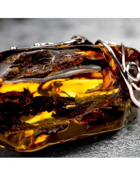Ciondolo in argento con ambra grezza color cognac: connessione con la natura e protezione spirituale.