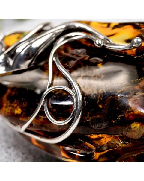 Ciondolo in argento con ambra grezza color cognac: connessione con la natura e protezione spirituale.