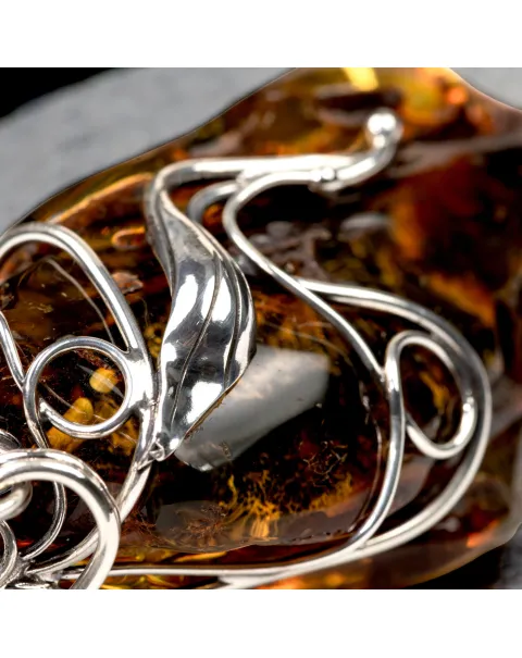 Ciondolo in argento con ambra grezza color cognac: connessione con la natura e protezione spirituale.
