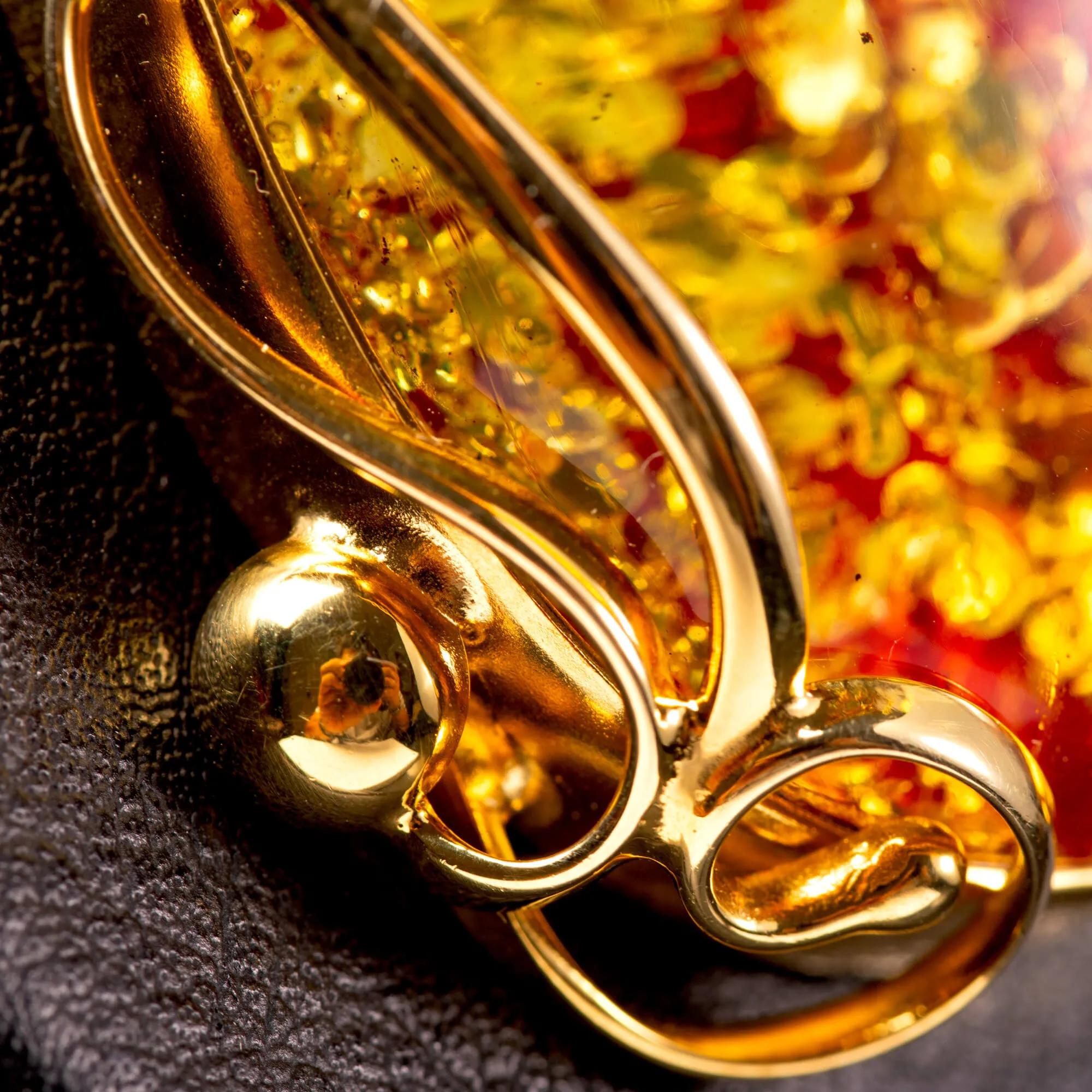 Ciondolo in ambra rosso cognac: gemma con inclusioni dorate, eleganza senza tempo.
