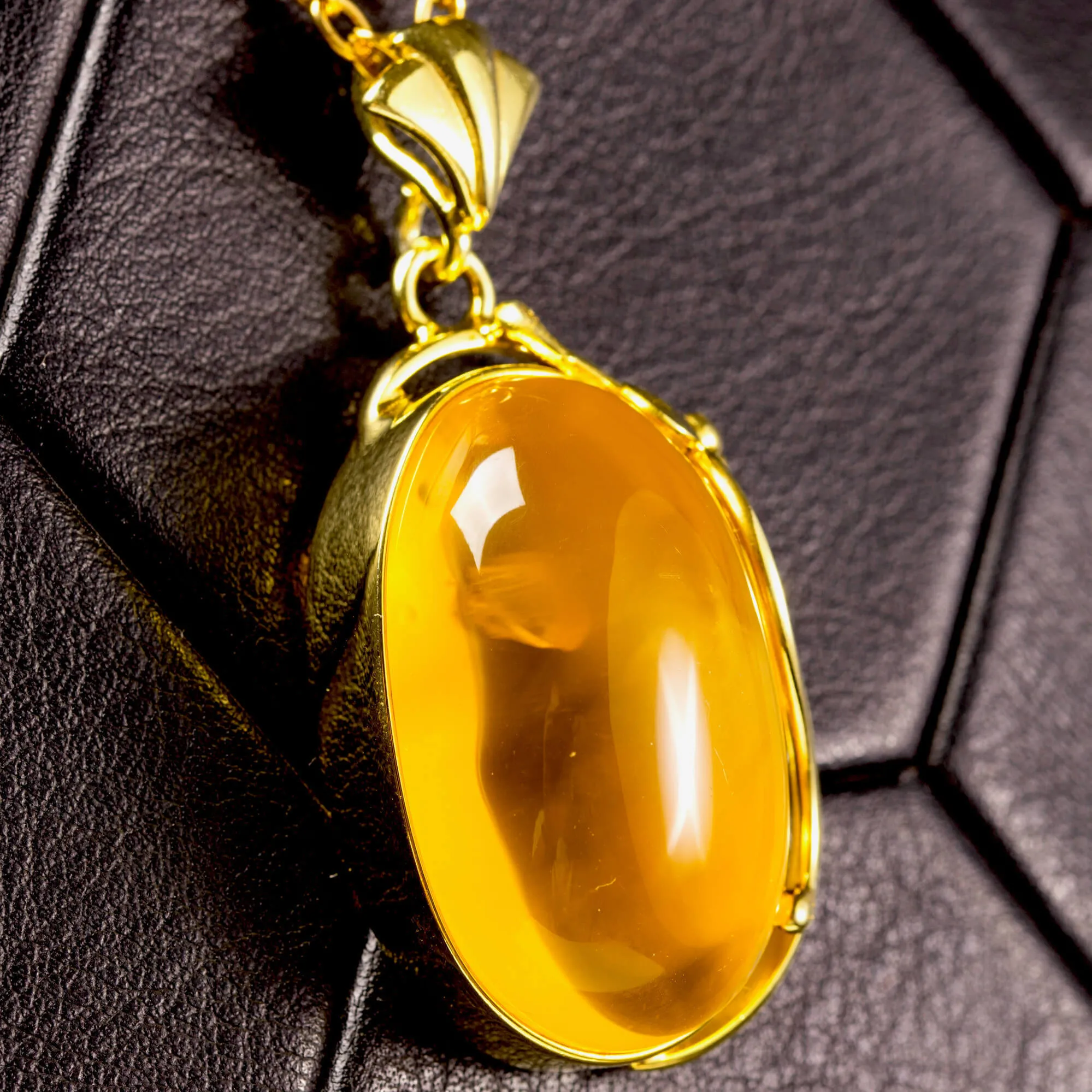 Ciondolo in ambra baltica color miele: pietra naturale incastonata in argento dorato.