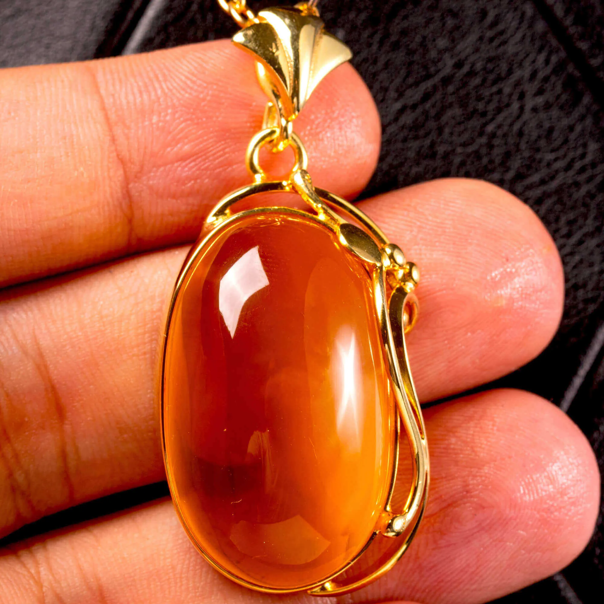 Ciondolo in ambra baltica color miele: pietra naturale incastonata in argento dorato.