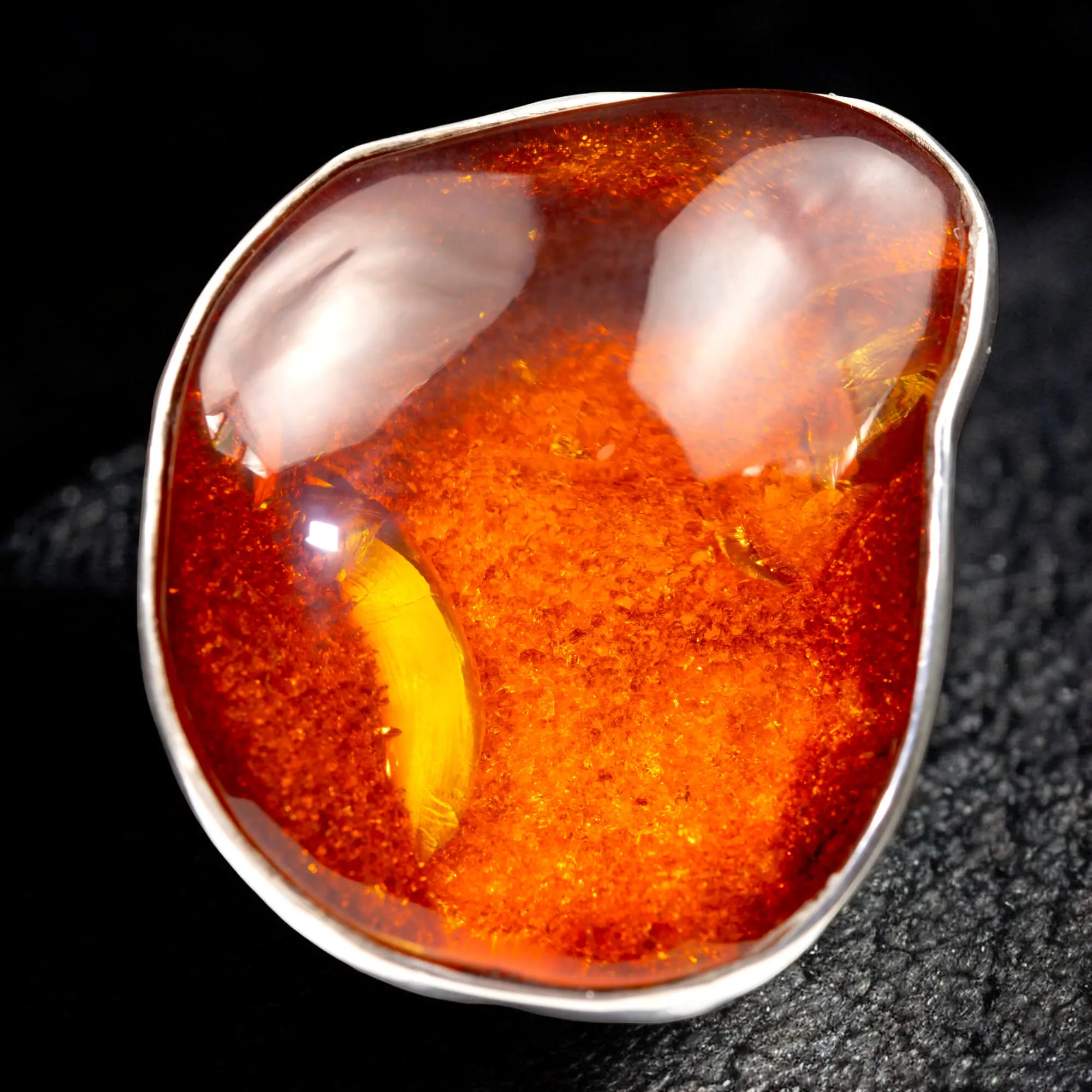 Anello in argento con ambra rossa e arancione: forza e protezione energetica.
