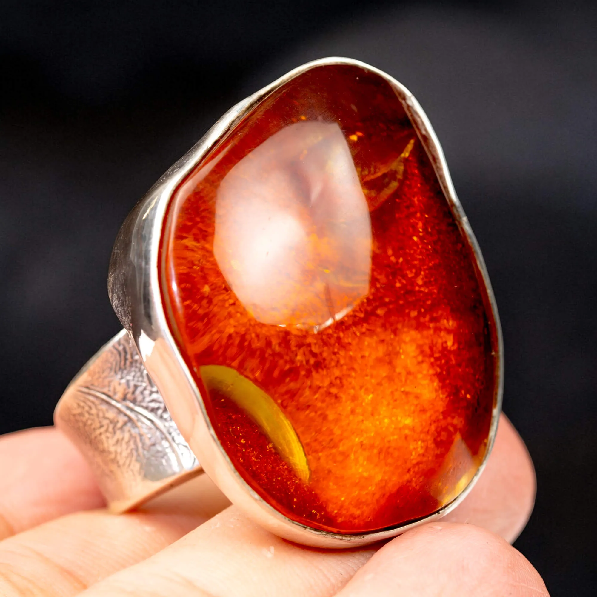 Anello in argento con ambra rossa e arancione: forza e protezione energetica.