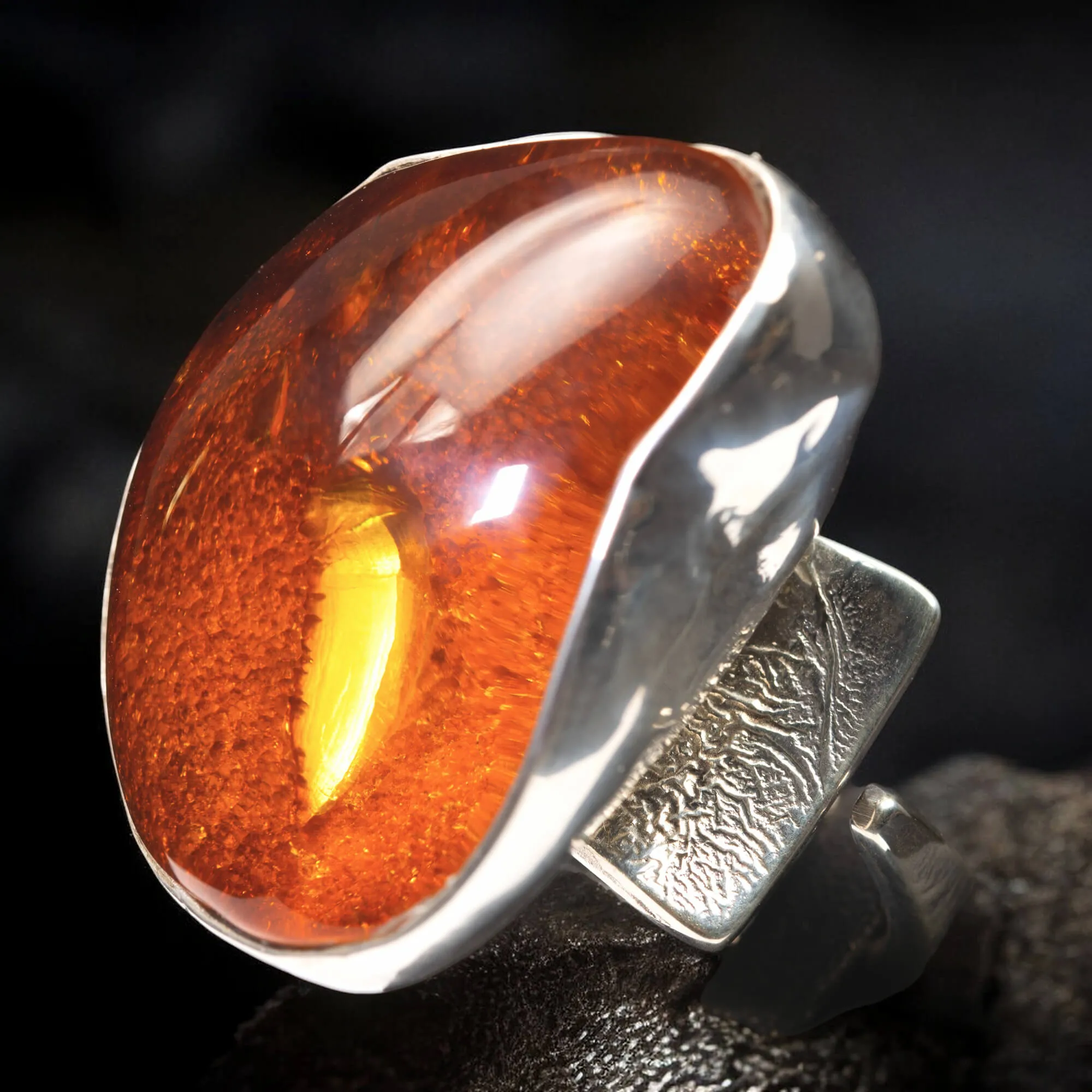 Anello in argento con ambra rossa e arancione: forza e protezione energetica.