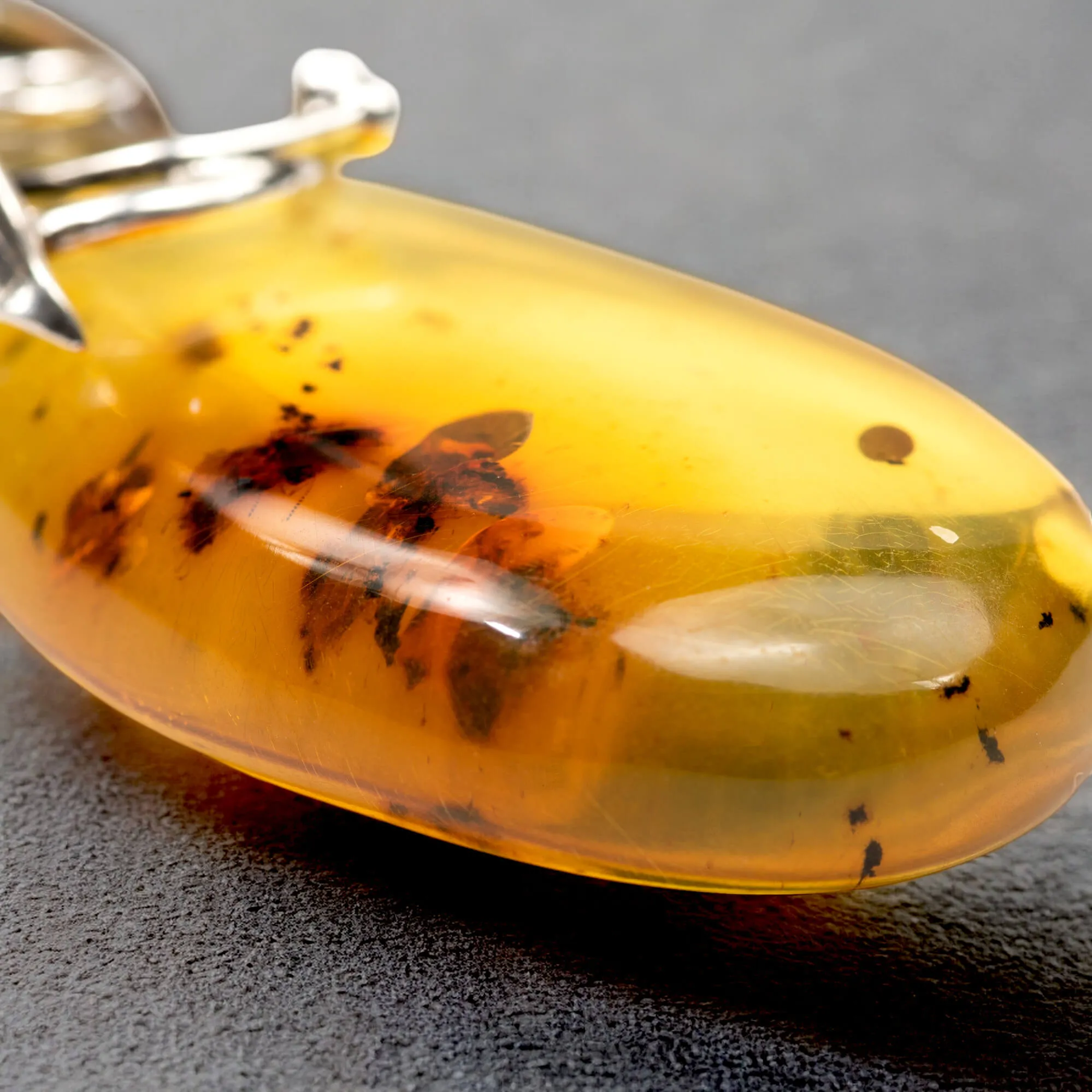Ciondolo in argento con ambra color miele: eleganza naturale e storia antica.