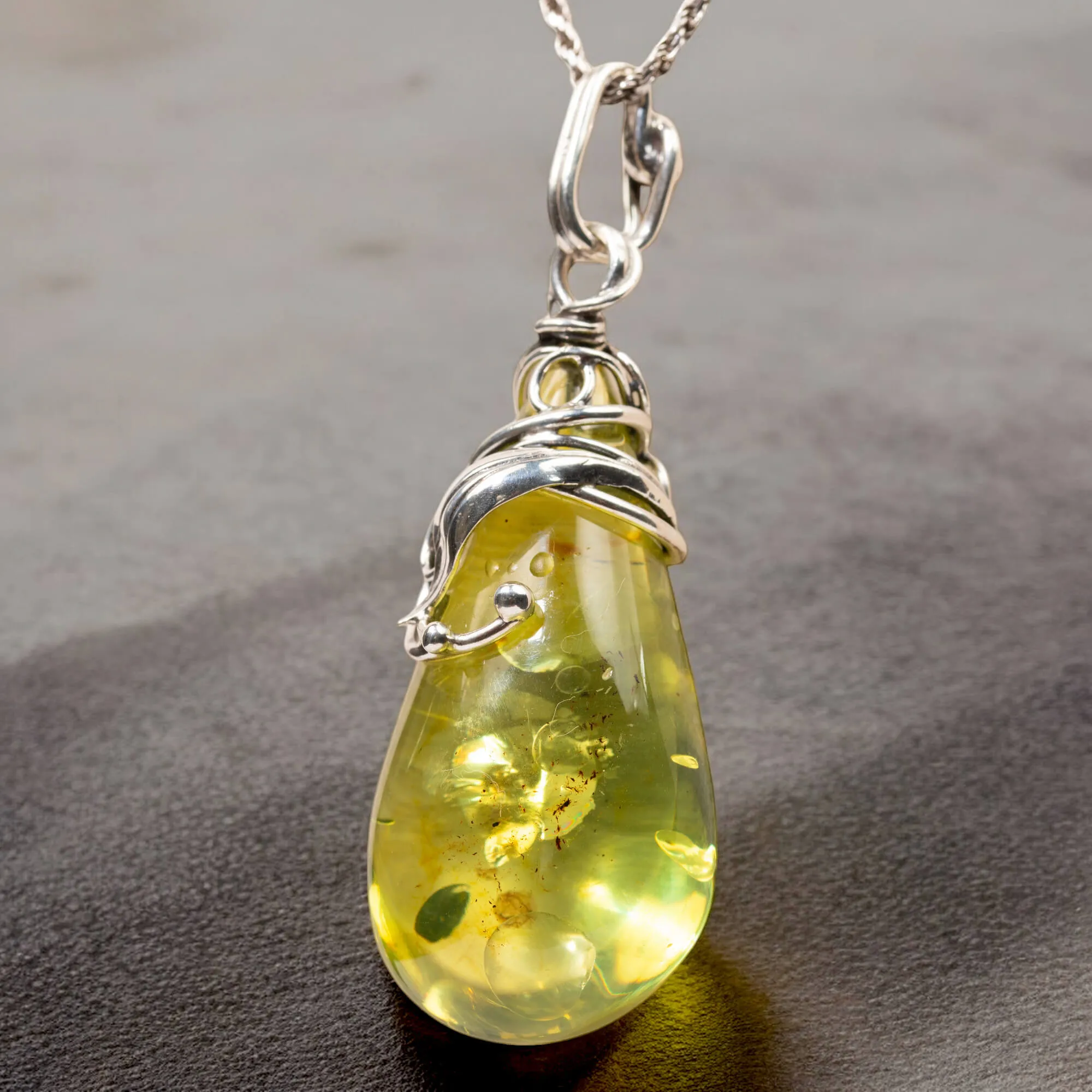 Ciondolo in argento con ambra verde: eleganza e armonia naturale.