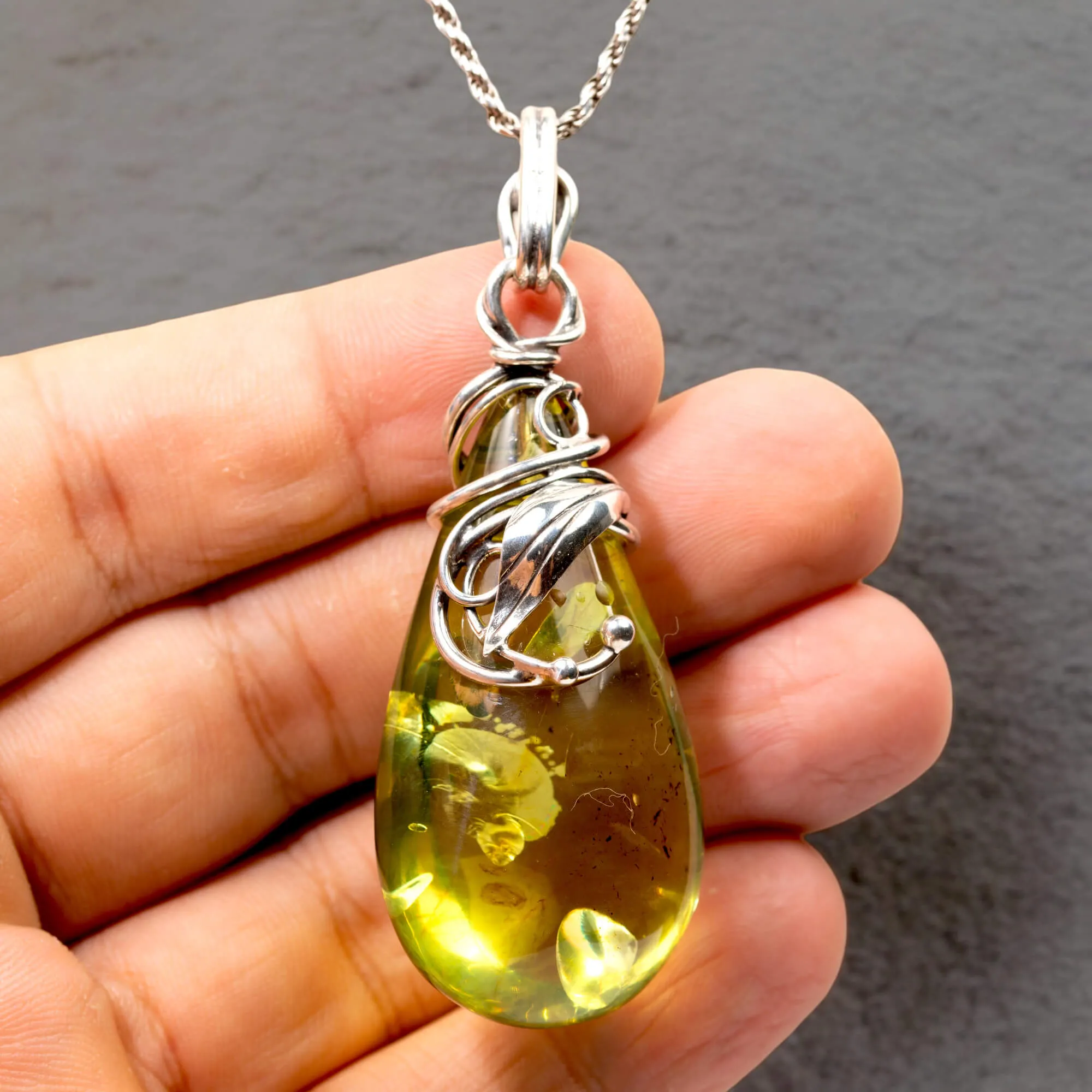 Ciondolo in argento con ambra verde: eleganza e armonia naturale.