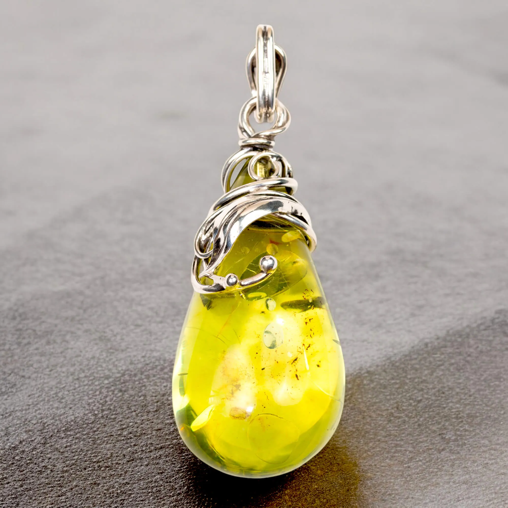 Ciondolo in argento con ambra verde: eleganza e armonia naturale.