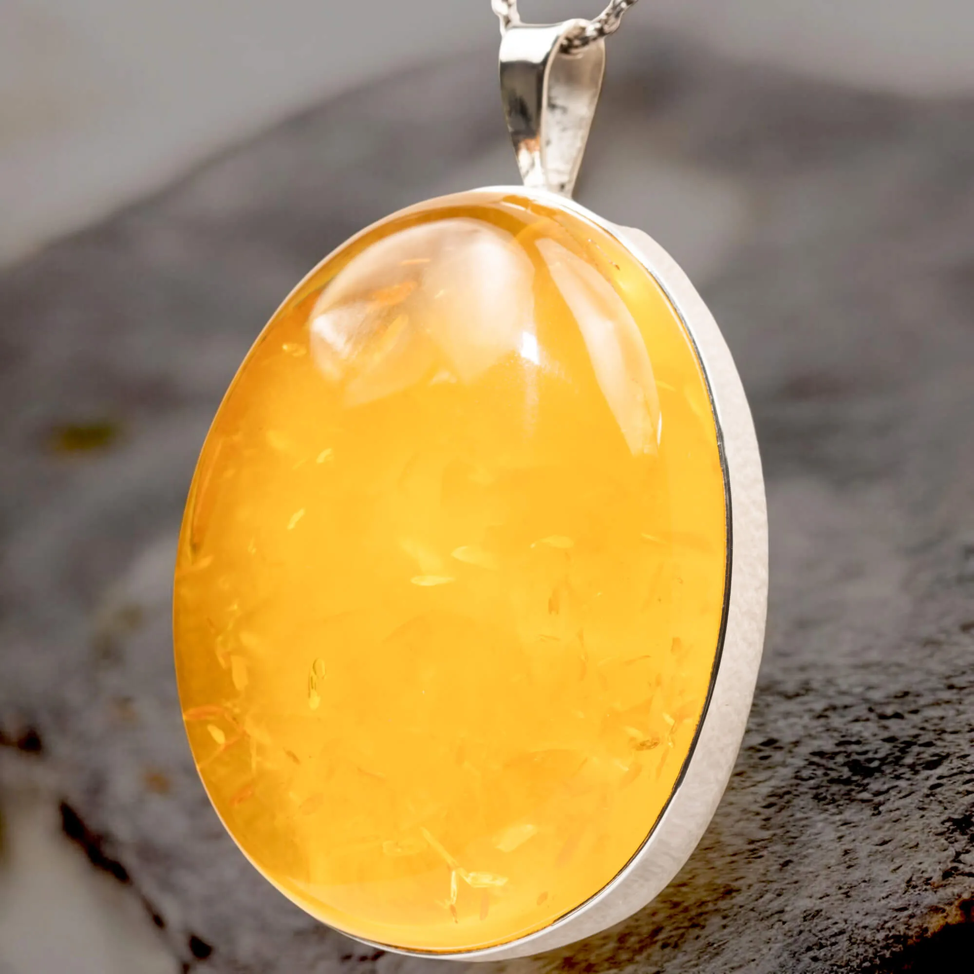 Ciondolo in argento con ambra color miele: eleganza e protezione energetica.