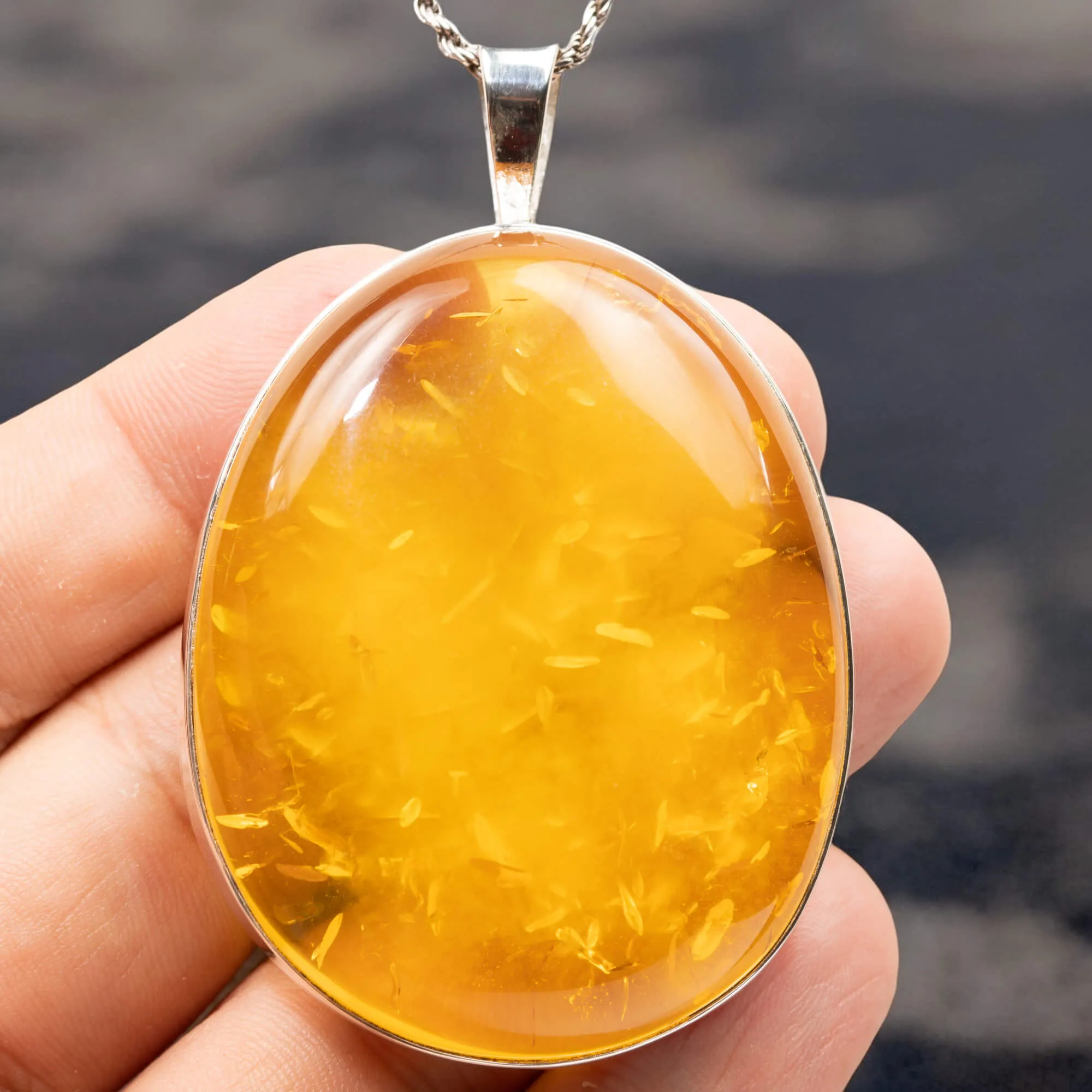 Ciondolo in argento con ambra color miele: eleganza e protezione energetica.