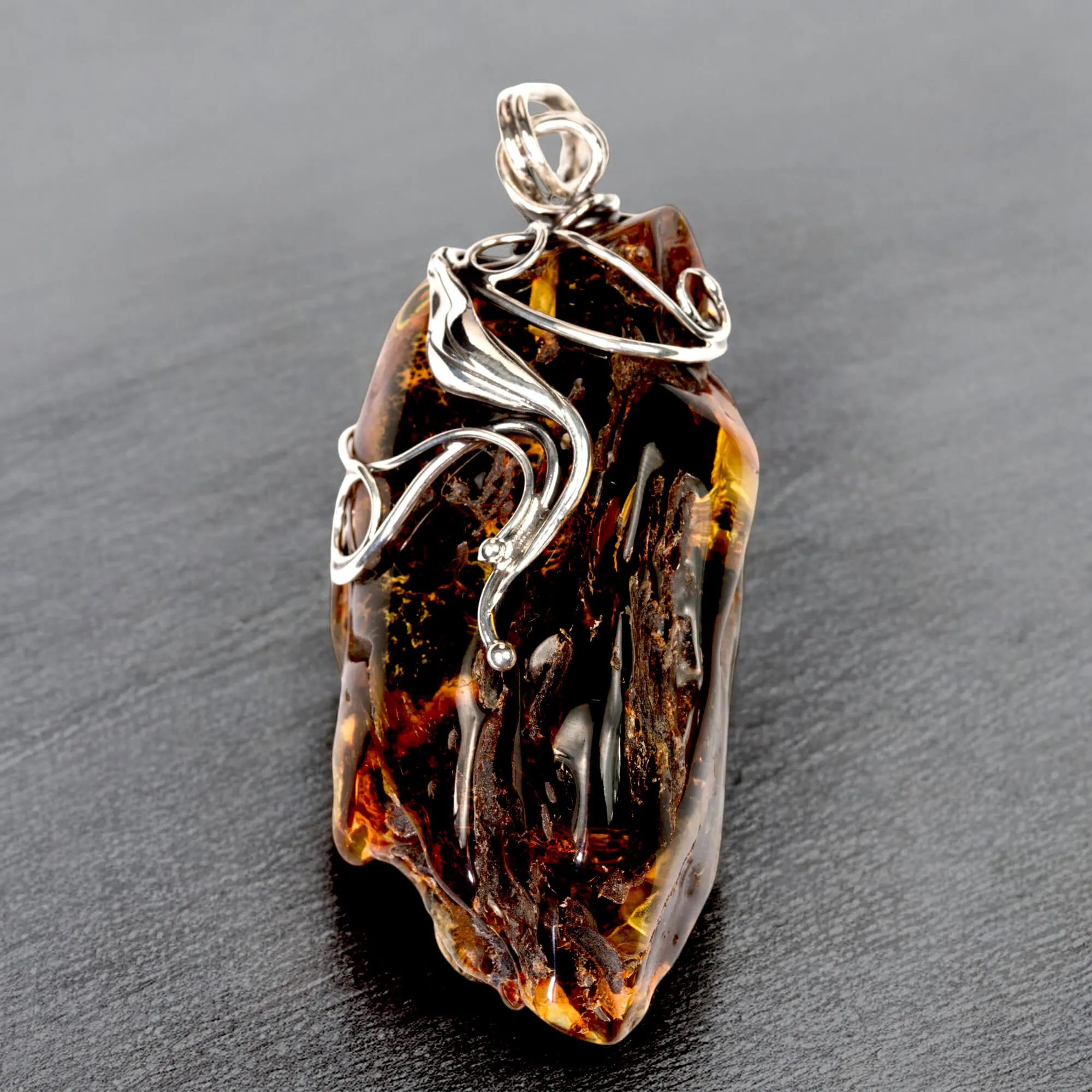 Ciondolo in argento con ambra grezza color cognac: connessione con la natura e protezione spirituale.