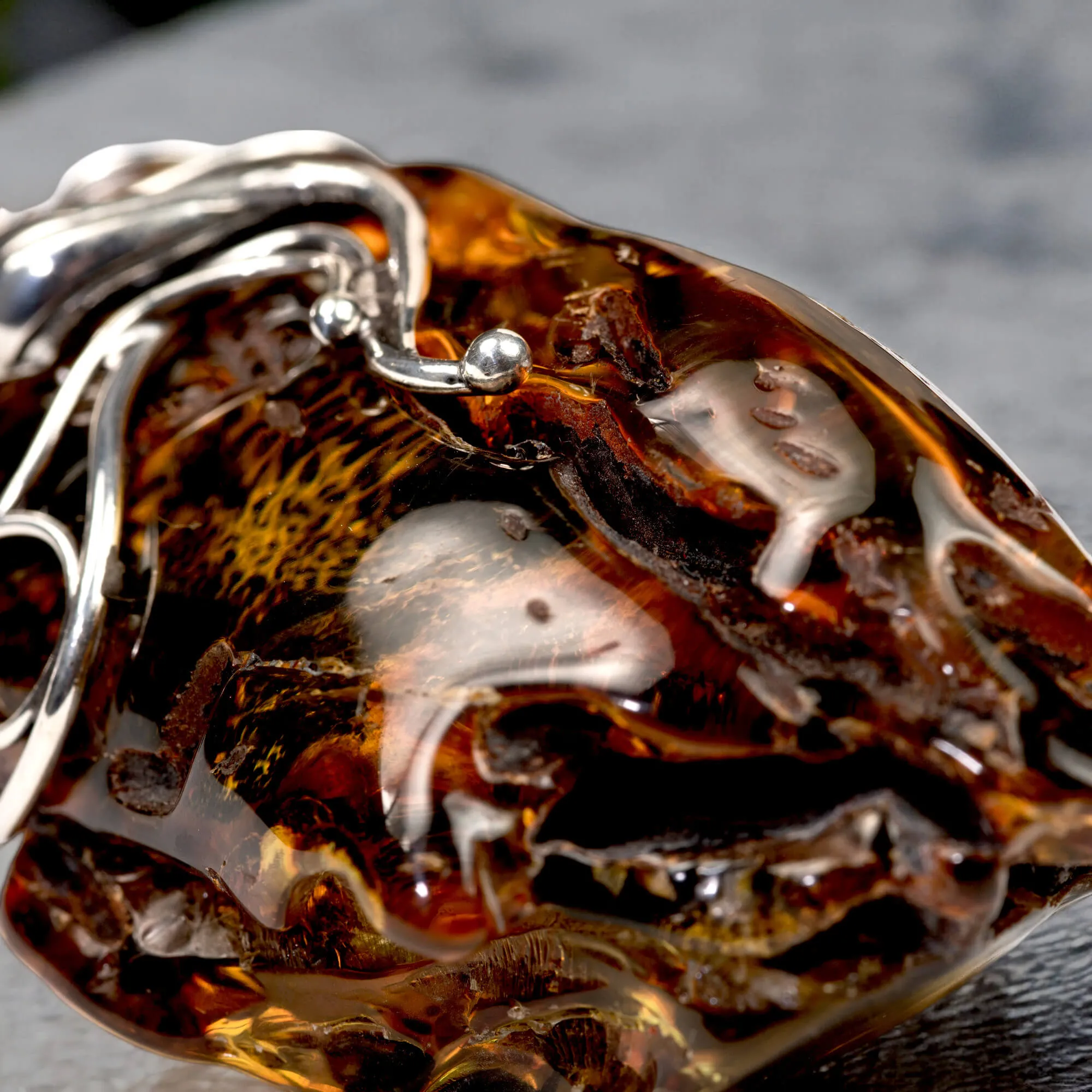 Ciondolo in argento con ambra grezza color cognac: connessione con la natura e protezione spirituale.