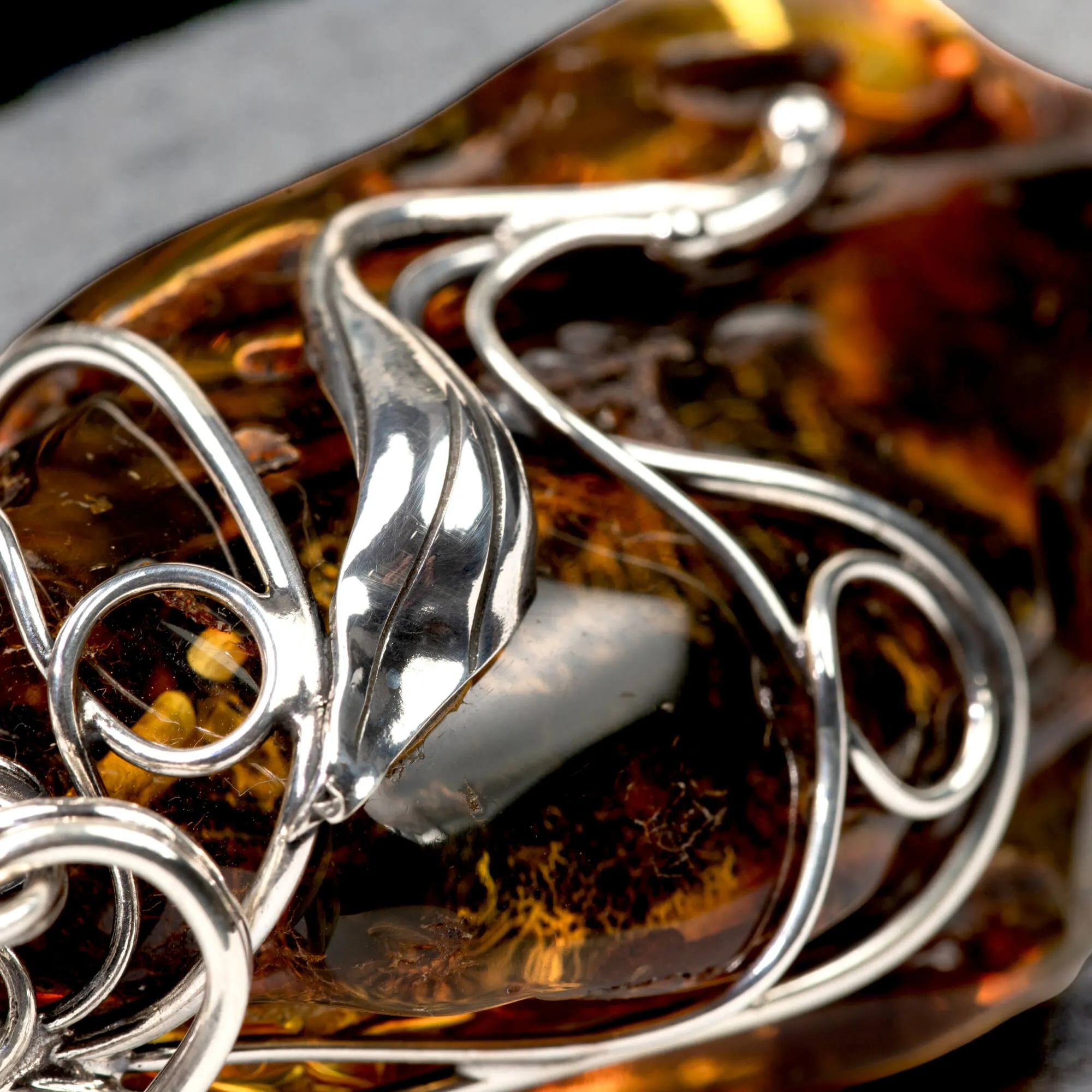 Ciondolo in argento con ambra grezza color cognac: connessione con la natura e protezione spirituale.
