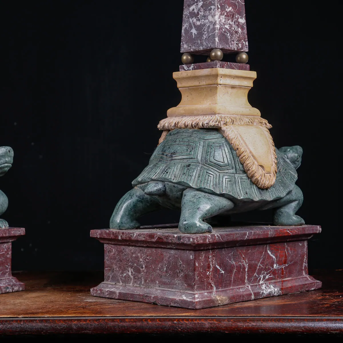 Coppia di obelischi in marmo con base scultorea a forma di tartaruga.